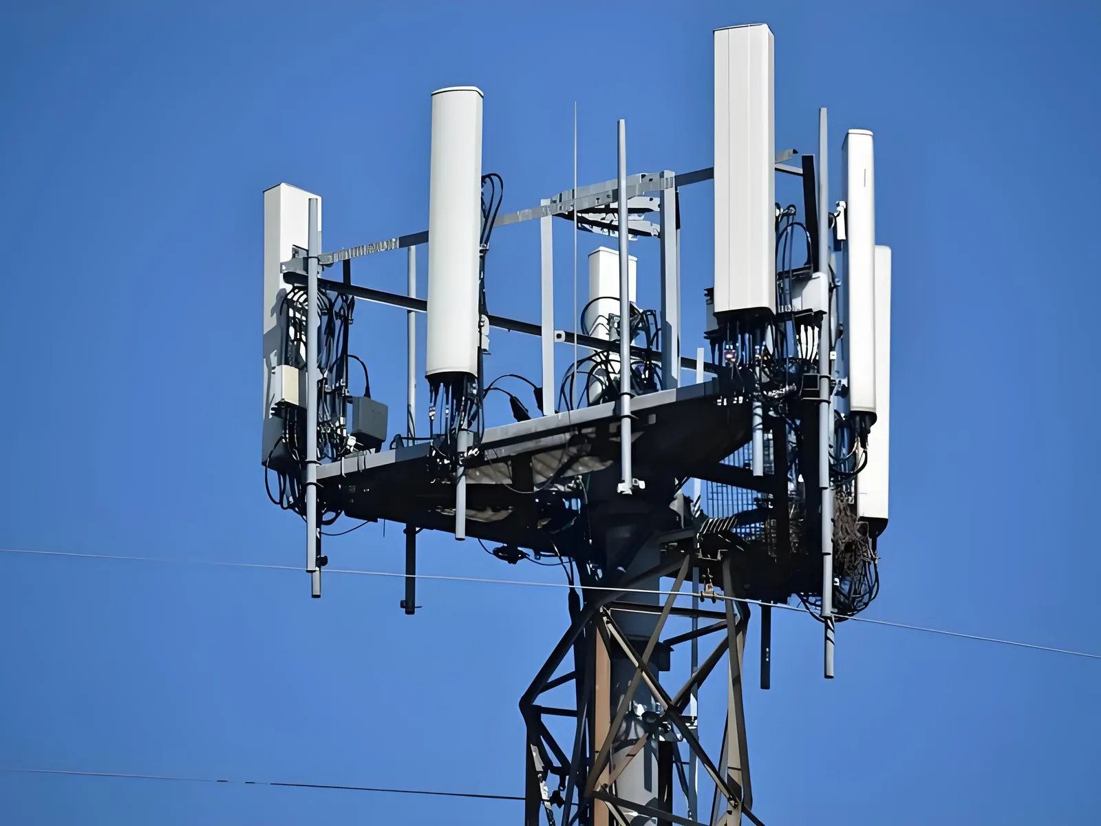Remote radio units mounted beside the antennas at the top of a 5G cell tower, the termination point of the fronthaul fiber run