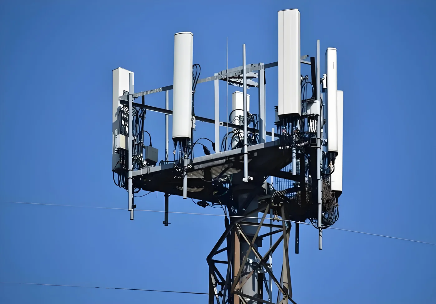 Macro cell tower antenna cluster with remote radio units and fiber jumper runs, the site type small-cell cable simplifies