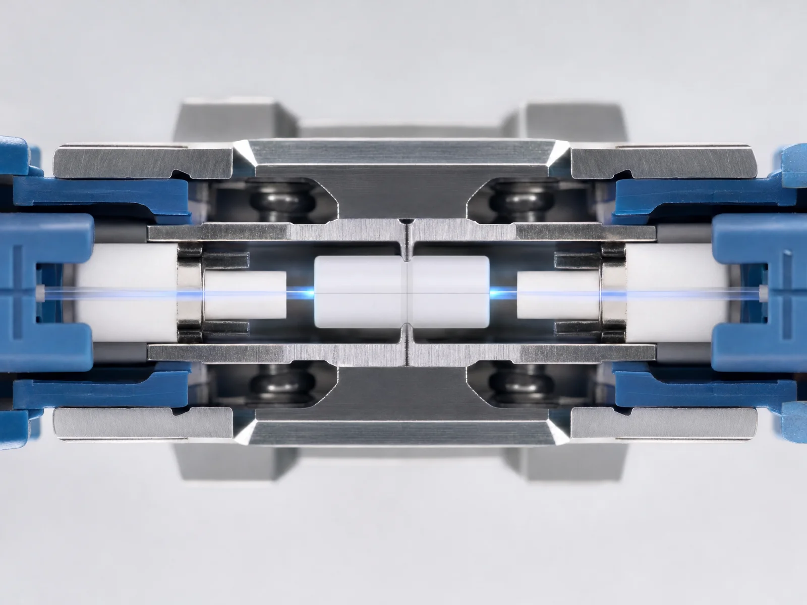 Cutaway view of two blue LC connectors whose white ceramic ferrules meet endface to endface inside a split alignment sleeve